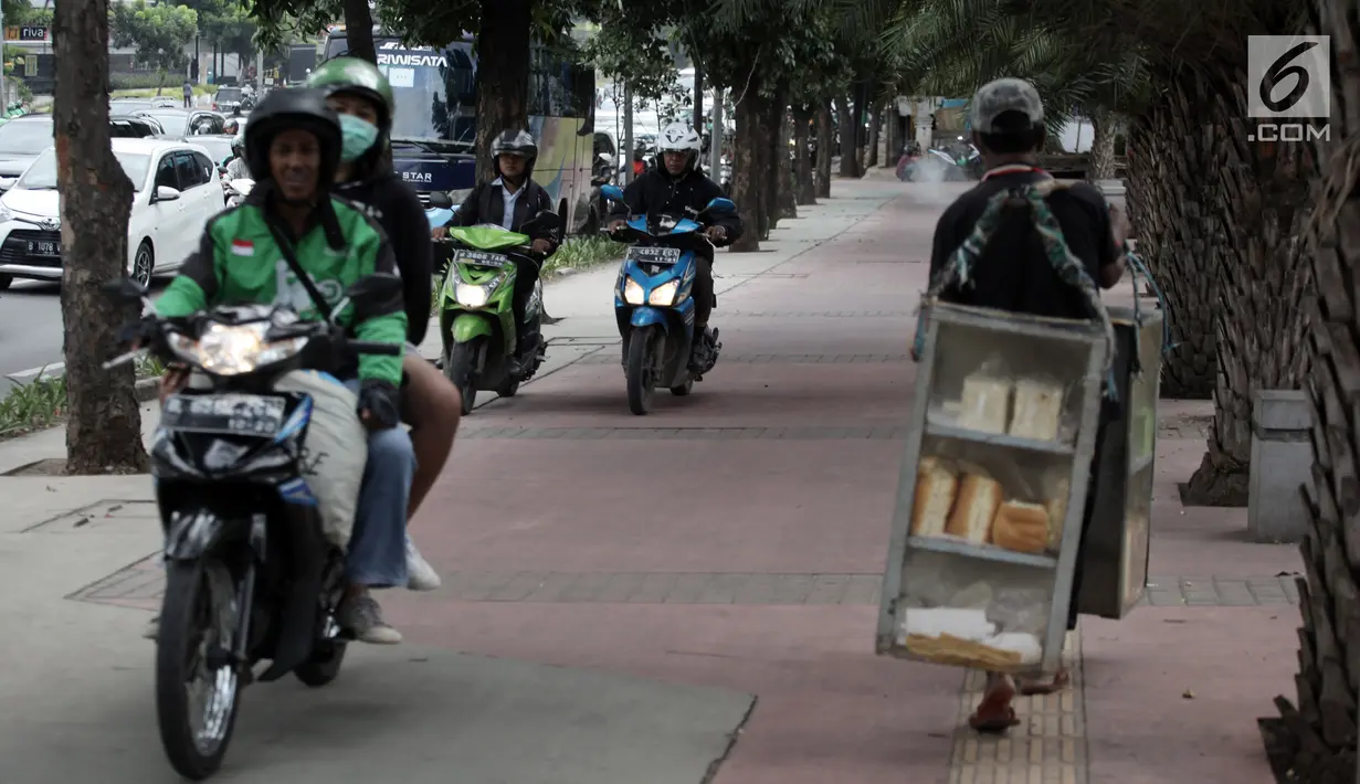 Sejumlah pengendara sepeda motor nekat menaiki jalur trotoar untuk menghindari kemacetan di Jalan Casablanca, Jakarta, Senin (8/1). Aksi tersebut dapat membahayakan keselamatan para pejalan kaki. (Liputan6.com/Arya Manggala Nuswantoro)