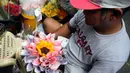 Seorang pekerja membuat karangan bunga yang terbuat dari mata uang kertas di pasar bunga di Manila, Filipina, Senin (13/2/2023). Buket tersebut merupakan bagian dari gimmick Hari Kasih Sayang oleh seorang pemilik toko bunga. (AP Photo/Aaron Favila)