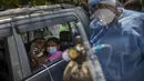 Seorang pasien menerima oksigen di dalam mobil yang disediakan oleh Gurdwara, tempat ibadah Sikh, di New Delhi, 24 April 2021. Banyak kota di India kewalahan oleh pasien yang mengakibatkan kekurangan tempat tidur rumah sakit dan oksigen yang menyebabkan ribuan kematian. (AP Photo/Rajesh Kumar Singh)