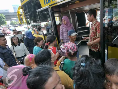 Warga saat menaiki bus tingkat City Tour Wisata Keliling Jakarta di halte Istiqlal, Jakarta, Kamis (7/7). Sejumlah warga memanfaatkan fasilitas bus wisata gratis untuk berkeliling Jakarta bersama keluarga. (Liputan6.com/Yoppy Renato)