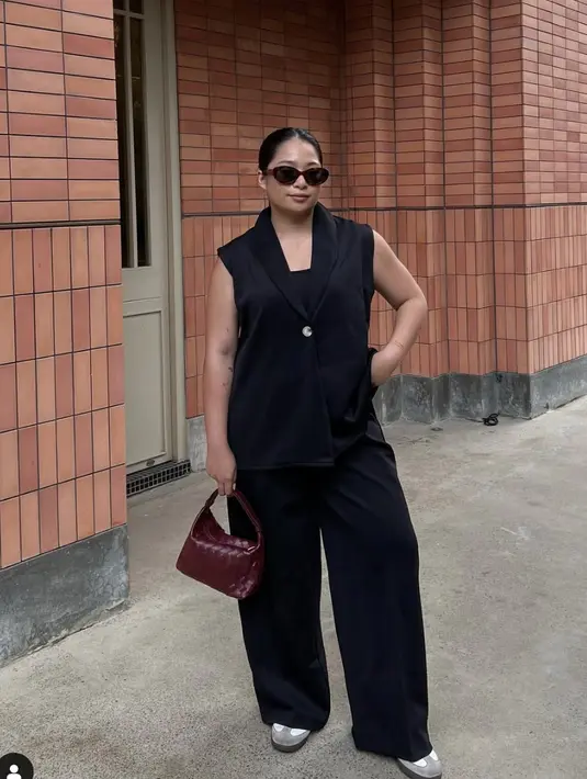 Kenakan one set hitam, ia memaksimalkan tampilan dengan tas bernuansa statement sehingga gayanya tidak terlihat flat. [Foto: Instagram/ Gaby Saputra]