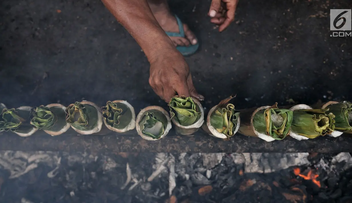 Pak Pian membakar lemang di sebuah tanah kosong di Jakarta, Minggu (27/5). Memasuki bulan Ramadan, produksi makanan tradisional Melayu berbahan dasar ketan tersebut terus meningkat. (Merdeka.com/Iqbal S Nugroho)