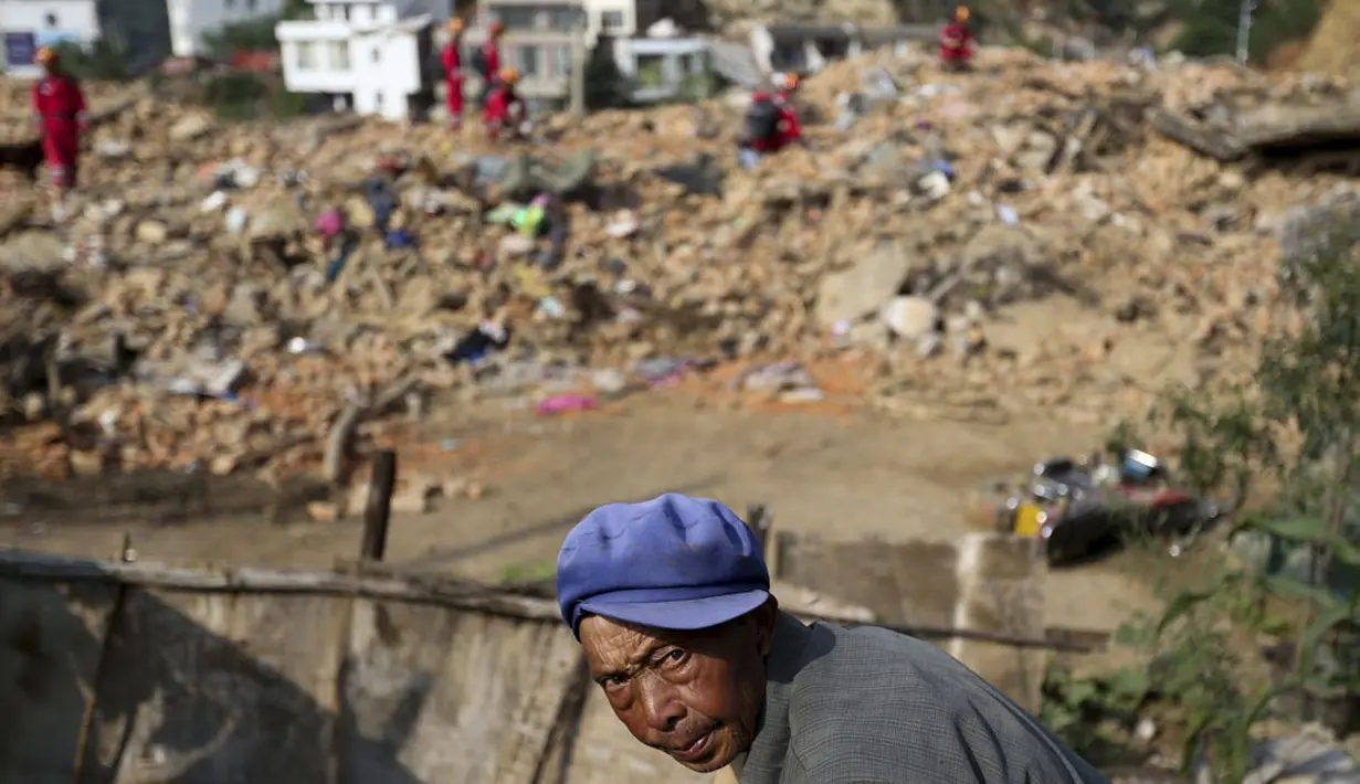 Salah satu korban melintasi puing-puing rumah yang hancur akibat gempa di Longtoushan, provinsi Yunan, Tiongkok, (6/8/2014). (REUTERS/Stringer)