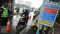 Petugas mengarahkan pengendara sepeda motor masuk menuju tol dalam kota di pintu tol Taman Mini 2, Jakarta, Kamis (21/4). Hujan deras yang mengguyur sejak semalam membuat sejumlah jalan di Ibu Kota tergenang banjir. (Liputan6.com/Angga Yuniar)