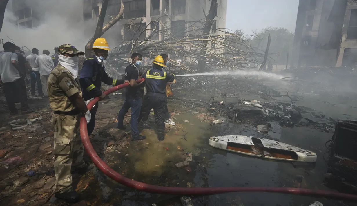 Petugas pemadam kebakaran bekerja di lokasi jatuhnya pesawat di kota Ahmedabad, negara bagian Gujarat, India Barat Laut, Kamis 12 Juni 2025. (AP/Ajit Solanki)