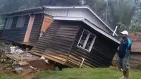 Seorang pria melihat kondisi sebuah rumah yang roboh akibat gempa melanda Papua Nugini, Selasa (27/2).Gempa berkekuatan 7,5 SR yang mengguncang pada Senin pagi juga merusak infrastruktur pertambangan dan listrik. (Jerol Wepii via AP)