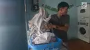 Petugas membantu konsumen menaruh cucian di sebuah laundry koin di Jakarta, Sabtu (8/6/2019). Pada libur Lebaran, jasa laundry ramai didatangi konsumen dengan sekali mencuci dibutuhkan dua koin seharga Rp 30 ribu. (merdeka.com/Imam Buhori)