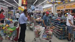 Warga Qatar mengantre untuk membayar belanjaan mereka di sebuah supermarket di Doha, Senin (5/6). Pasca diumumkan pemutusan hubungan Diplomatik Qatar-Saudi, warga Qatar menyerbu toko makanan untuk memenuhi stok barang kebutuhan mereka. (Doha News via AP)