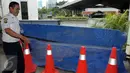 Petugas menutupi lokasi jatuhnya mobil Toyota Kijang warna merah marun dari lantai 3 Gedung Migas, Jakarta, Selasa (5/4). Mobil itu menabrak dinding pembatas di lantai 3 dan kemudian jatuh terbalik. (Liputan6.com/Helmi Affandi)