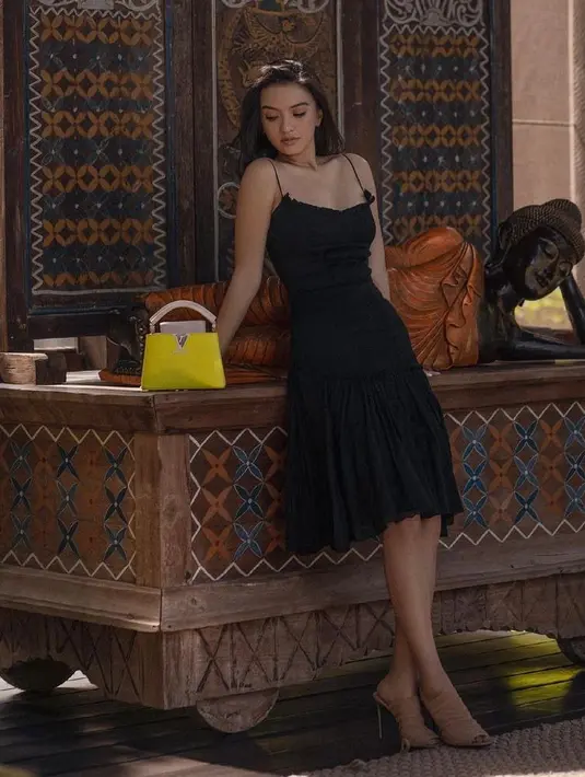 Buat ke pesta dress model strap spaghetti warna hitam dengan aksen rempel bikin penampilan terlihat elegan.  (Instagram/ralineshah).