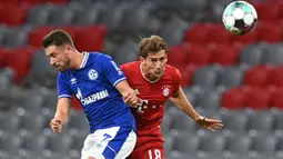 Gelandang Bayern Munchen, Leon Goretzka, berebut bola dengan penyerang Schalke, Mark Uth, pada laga Liga Jerman di Allianz Arena, Sabtu (19/9/2020) dini hari WIB. Bayern Munchen menang 8-0 atas Schalke. (AFP/Christof Stache)