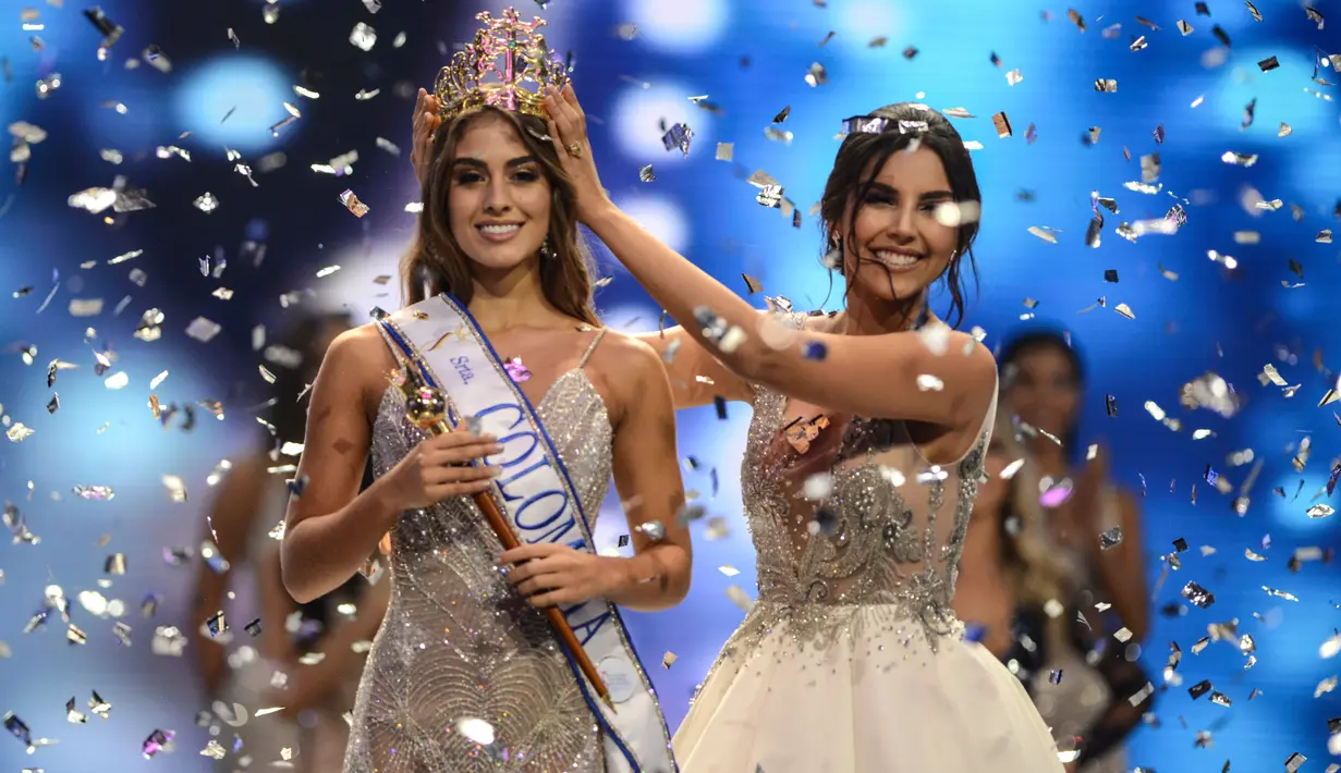 Miss Valle del Cauca Valeria Morales (kiri) menerima mahkota Miss Colombia 2018 dari Laura Gonzales selama kontes kecantikan Miss Colombia di Medellin (30/9). Wanita 20 tahun ini lahir di Santiago de Cali pada 2 Januari 1998. (AFP Photo/Joaquin Sarmiento)