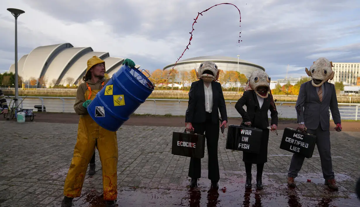 Juru kampanye dari kelompok lingkungan Ocean Rebellion mengenakan topeng kepala ikan saat aksi protes terhadap Marine Stewardship Council (MSC) di Glasgow, Skotlandia, 4 November 2021. Aksi ini dilakukan di sela-sela KTT Iklim PBB COP26 yang sedang berlangsung. (AP Photo/Alastair Grant)