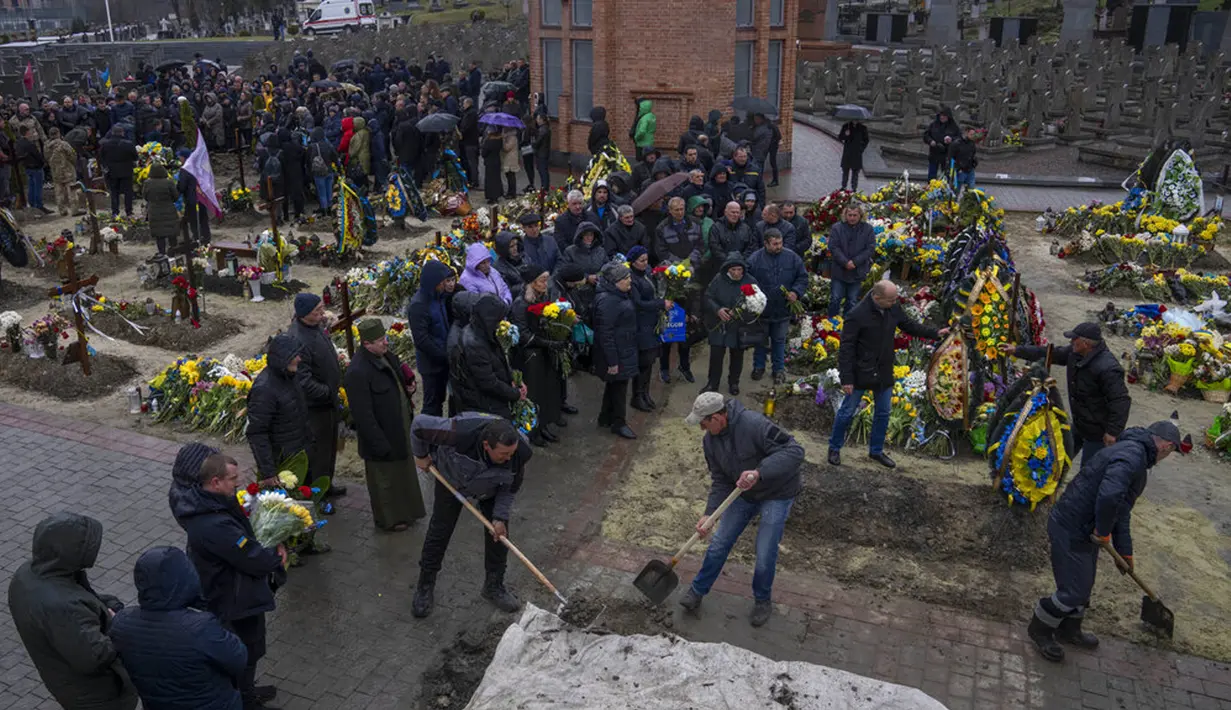 Keluarga dan teman menghadiri pemakaman seorang tentara yang tewas dalam perang dengan Rusia di pemakaman Lychakiv, Lviv, Ukraina, Selasa (5/4/2022). (AP Photo/Nariman El-Mofty)