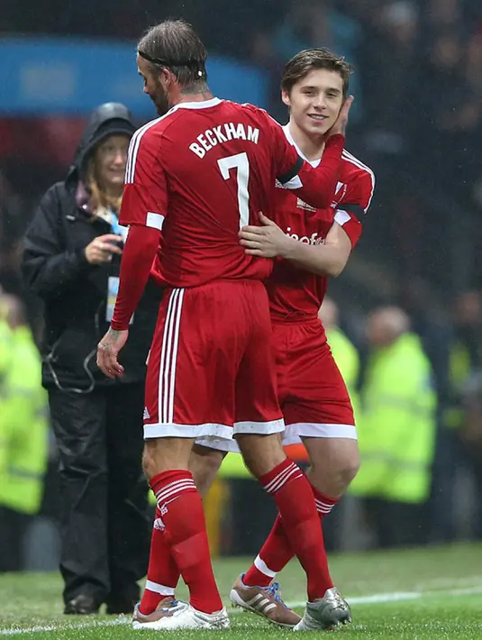 David Beckham (kiri) saat digantikan anaknya Brooklyn pada laga amal di Old Trafford, Inggris, Sabtu (14/11/2015). David David Beckham dan Brooklyn sama - sama mengenakan nomor punggung 7. (Dailymail)