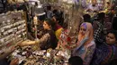 Perempuan Pakistan memilih perhiasan dan  gelang tradisional di sebuah pasar di Lahore, Selasa (12/6). Umat muslim di berbagai penjuru dunia sedang mempersiapkan untuk merayakan Idul Fitri, yang menandai berakhirnya bulan suci Ramadan. (AP/K.M. Chaudary)