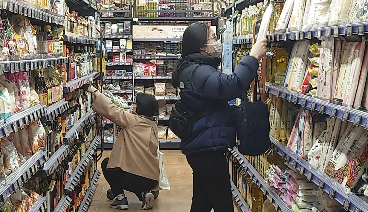 Orang-orang mengenakan masker saat berbelanja di supermarket di Taipei, Taiwan, Senin (20/2/2023). Pada bulan Desember, Taiwan membatalkan mandat topeng luar ruangannya, yang mengharuskan orang untuk memakai topeng bahkan saat berjalan di jalan. (AP Photo/Chiang Ying-ying)
