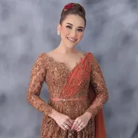 Saat hari-H pernikahan Syifa, Ayu Ting Ting mengenakan kebaya warna teracota. Detail kerah v-neck membuat lehernya terlihat lebih jenjang. Ditambah, aksen selendang di bahu dan taburan beads yang membuat penampilan Ayu semakin elegan. [@ayutingting92]