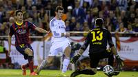 Gareth Bale memenangi sprint melawan Marc Bartra sebelum menaklukkan kiper Jose Manuel Pinto dalam final Copa del Rey di Stadion Mestalla, Valencia (16/4/2014). (AFP Photo/Dani Pozo)