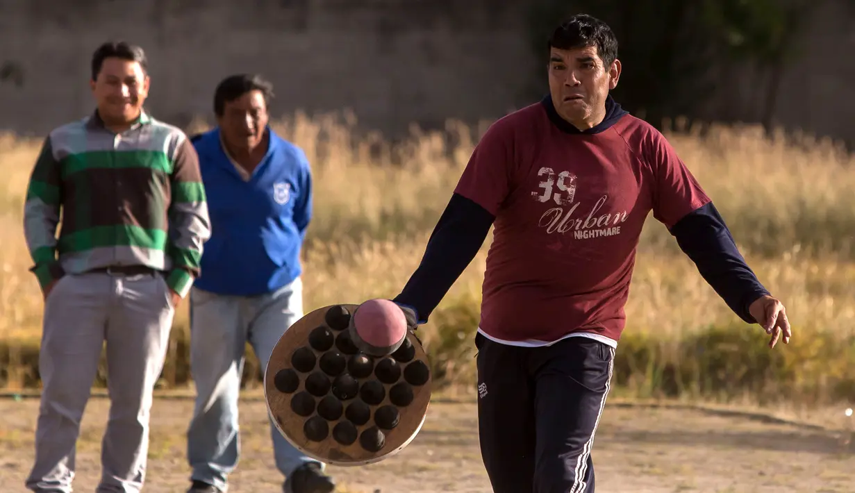 Seorang pria bersiap memukul bola saat bermain "pelota nacional" atau bola nasional di Quito, Ekuador (24/7). Olahraga ini banyak dimainkan di Narino, Kolombia, dan merupakan olahraga nasional Ekuador. (AFP Photo/Juan Cevallos)