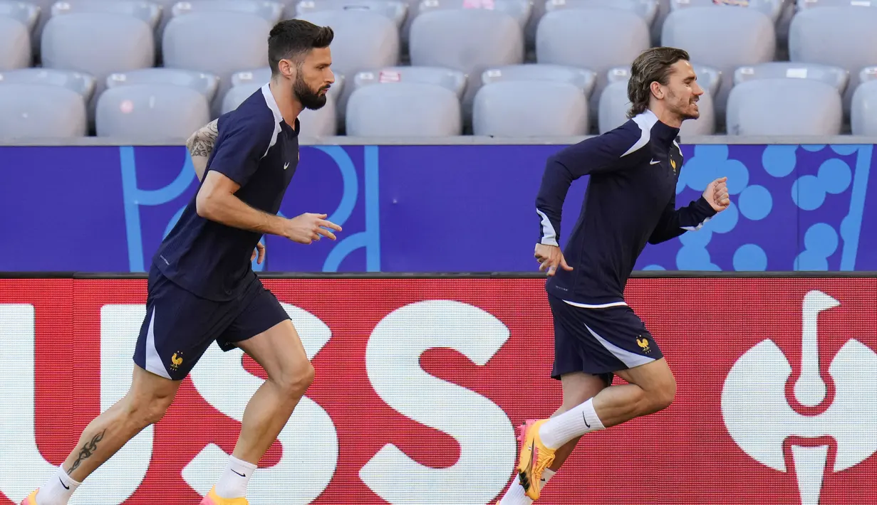 Pemain Prancis, Antoine Griezmann dan Olivier Giroud, berlari bersama saat mengikuti sesi latihan di Munich, Jerman, Senin (8/7/2024). (AP Photo/Hassan Ammar)