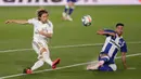 Gelandang Real Madrid Luka Modric melepaskan tembakan yang berusaha dihentikan pemain Alaves, Victor Camarasa pada lanjutan Liga Spanyol di stadion Alfredo di Stefano, Sabtu (11/7/2020). Real Madrid menang 2-0 lewat gol Karim Benzema dan Marco Asensio. (AP Photo/Bernat Armangue)