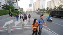 Sejumlah karyawan terpaksa berjalan kaki usai pulang kerja di kawasan Thamrin, Jakarta, Selasa (21/5). Akibat adanya aksi masa tolak hasil pemilu 2019 membuat sejumlah ruas jalan di kawasan tersebut di tutup. (Liputan6.com/Angga Yuniar)