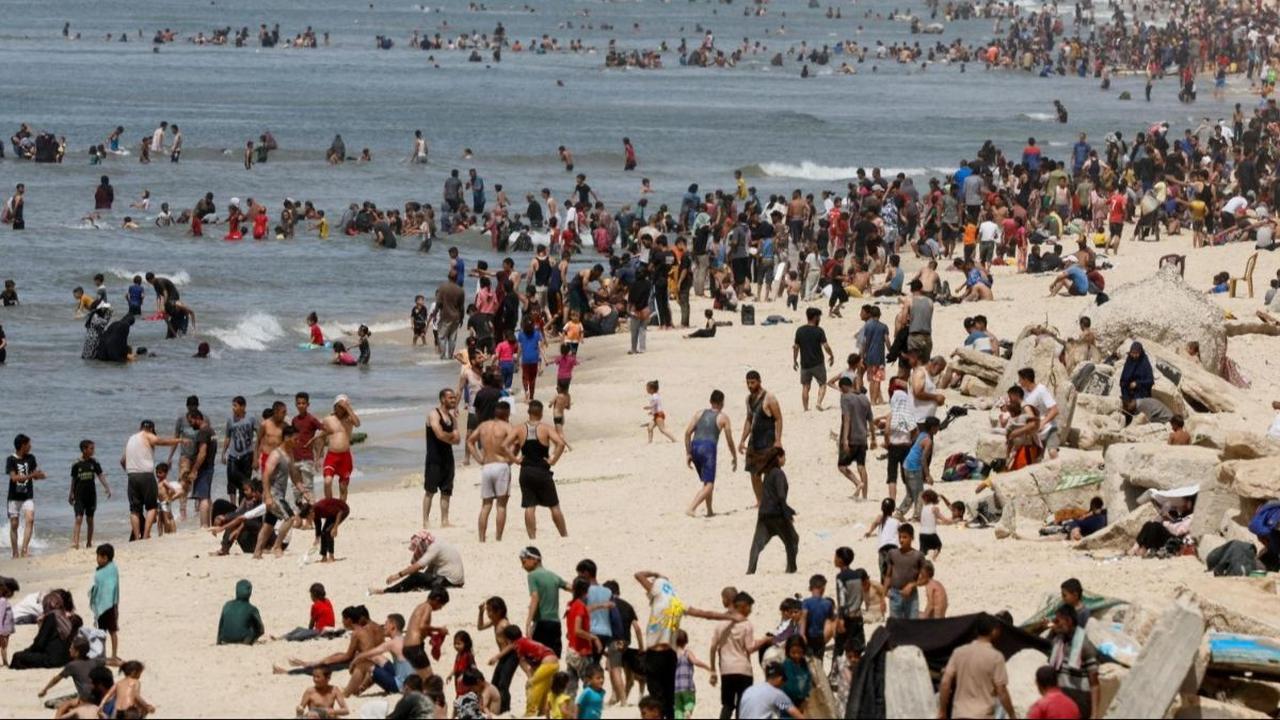 Tak sedikit warga Palestina menikmati waktu santainya di pantai Gaza dengan berjemur dan berenang di musim panas saat ketegangan antara Israel dan Hamas masih berlangsung di Rafah, di selatan Jalur Gaza, 24 April 2024. Foto: REUTERS / Mohammed Salem