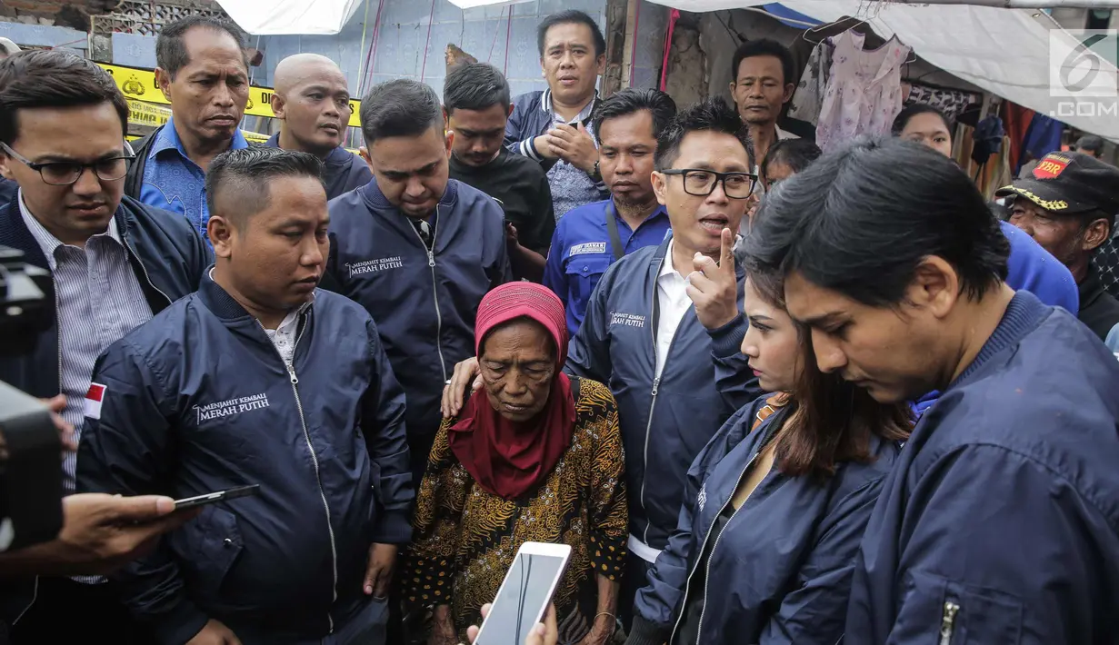 Artis sekaligus Ketua DPW PAN DKI Jakarta Eko Patrio bersama para pekerja seni berbincang dengan salah satu warga saat menyambangi lokasi kebakaran di Taman Sari, Jakarta, Senin (5/2). (Liputan6.com/Faizal Fanani)