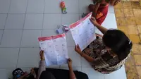 sejumlah ibu-ibu di Kabupaten Bangkalan, melihat contoh surat suara sebelum ke TPS. mereka melakukan ini karena bingung sebab jumlah surat suara begitu banak