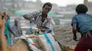 Seorang pria menaikan garam ke punggung unta di area tambang garam di Danakil Depression, Afar, Ethiopia (28/3). Penduduk Ethiopia banyak yang menggantungkan hidup mereka sebagai penambang garam. (AFP Photo/Zacharias Abubeker)