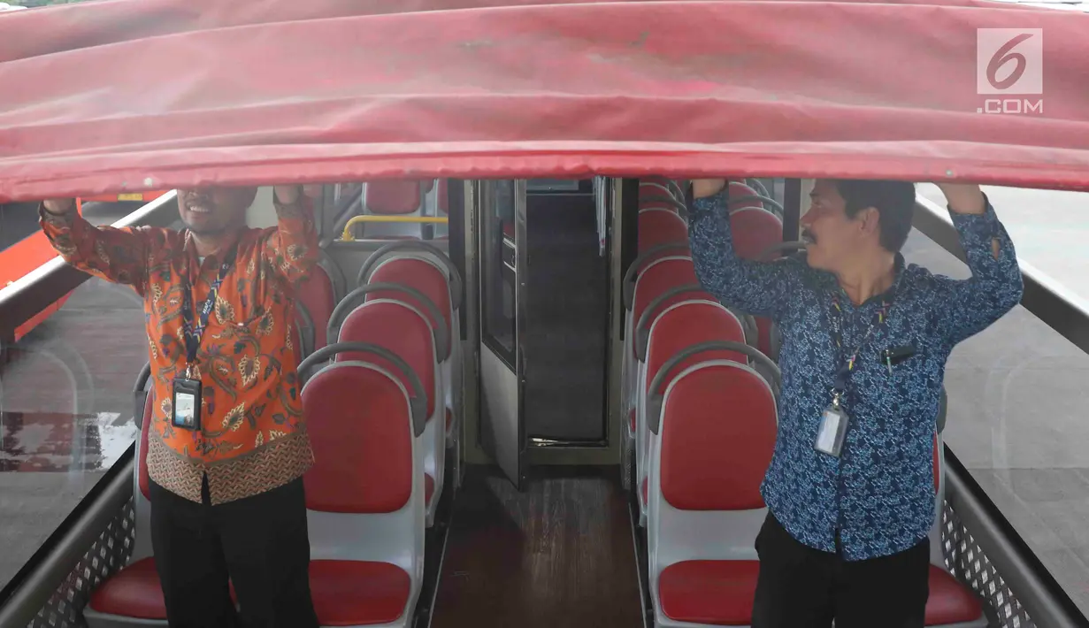 Petugas mengecek bus transjakarta yang akan digunakan untuk pawai kemenangan tim sepak bola Persija Jakarta di kantor PT Transjakarta, Cawang, Kamis (13/12). Bus tersebut akan digunakan untuk pawai kemenangan Persija. (Liputan6.com/Immanuel Antonius)