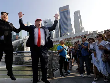 Kim Jong-un KW bernama Howard X dan Donald Trump KW, Dennis Alan berpose sambil melompat bersama di Merlion Park, Singapura (8/6). Dua orang yang mirip pemimpin negara Korut dan AS ini menghebohkan warga dan pengunjung. (AP/Wong Maye-E)