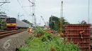  Kereta milintas di dekat proyek pembangunan jalur dua rel ganda atau double-double track (DDT) Manggarai-Cikarang, Jakarta, Jumat (13/1). Menhub mengungkapkan, kendala proyek DDT ini adalah administrasi pembebasan lahan. (Liputan6.com/Gempur M Surya)