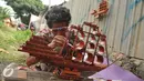 Perajin merekatkan miniatur perahu phinisi yang terbuat dari bambu, Jawa Barat, Sabtu (9/7). Perajin mengaku membanjirnya produk kerajinan dari China menyebabkan terhentinya ekspor dan penurunan permintaan dalam negeri. (Liputan6.com/Gempur M Surya)