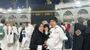 Berpose di depan Ka'bah, ketiga kompak mengenakan outfit hitam-putih. Atta dengan outfit serba putih menggendong Ameena dengan outfit hitam lengkap dengan hijabnya, serasi dengan Aurelie yang juga mengenakan outfit serba hitam. Foto: Instagram.