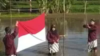Pasukan pengibar bendera meski susah payah berbaris, tetap menjaga agar bendera tetap bersih. (foto: Liputan6.com/agus gendut/edhie prayitno ige)
