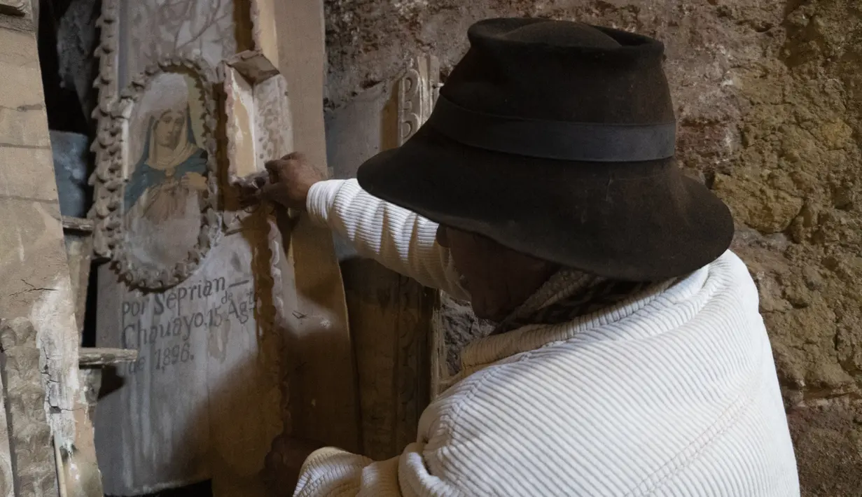 Penjaga dan gembala alpaka Esteban Taipe memindahkan bagian altar yang rusak dengan gambar Perawan Maria yang dilukis pada 15 Agustus 1896, oleh seniman Pribumi Seprian Chauayo, di gereja kota hantu Santa Barbara, Peru, Kamis (2/12/2021). (AP Photo/Franklin Briceño)