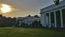 Suasana di Halaman Istana Bogor saat gerhana tengah berlangsung. Dengan mengenakan kemeja putih dan sarung kotak-kotak berwarna biru, Jokowi tampak santai menyaksikan gerhana matahari di halaman Istana Bogor, Rabu (9/3). (facebook.com/Jokowi)