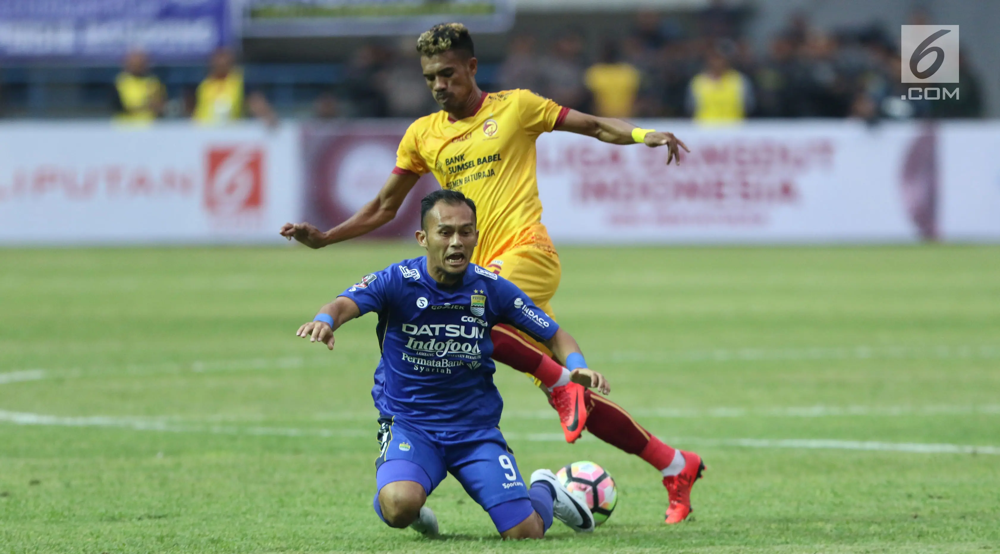 Penyerang Persib, Airlangga terjatuh saat berebut bola dengan pemain Sriwijaya FC, Alfin Tuasalamony pada laga pembuka Piala Presiden 2018 di Stadion GBLA, Bandung, Selasa (16/1). Persib unggul 1-0. (/Helmi Fithriansyah)