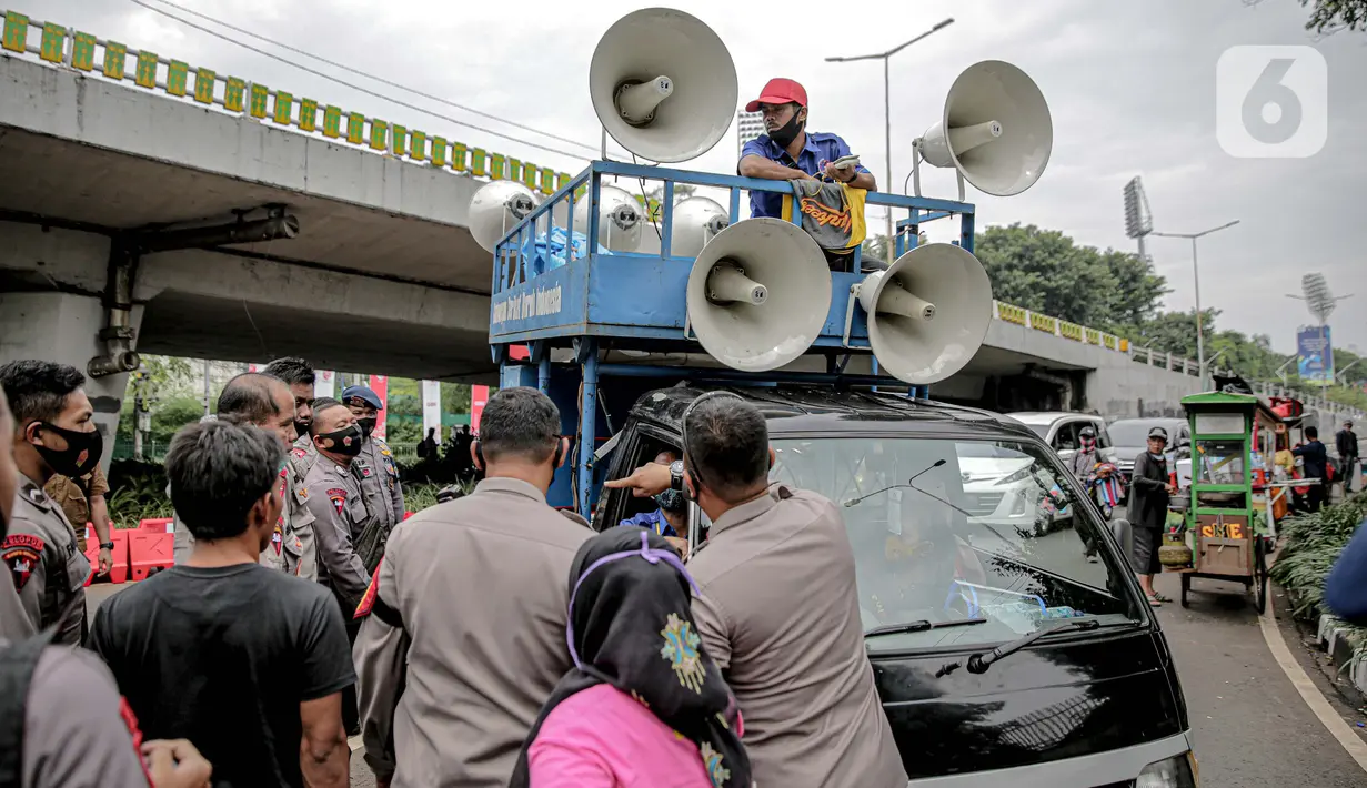 Petugas kepolisian yang berjaga memberhentikan mobil komando aksi di sekitar Gedung DPR, Jakarta, Jumat (14/8/2020). Polda Metro Jaya melarang adanya unjuk rasa di depan Gedung DPR/MPR yang bertepatan dengan sidang tahunan sekaligus pidato kenegaraan Presiden Jokowi. (Liputan6.com/Faizal Fanani)