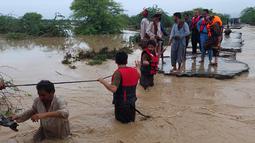 Petugas penyelamat membantu penduduk desa untuk mengevakuasi mereka dari daerah banjir yang disebabkan hujan lebat, di Lasbella, sebuah distrik di provinsi Baluchistan barat daya Pakistan (26/7/2022). Para pejabat mengatakan, pada hari Rabu, penyelamat yang didukung oleh pasukan menggunakan perahu dan helikopter untuk mengungsi ratusan orang terdampar dari barat daya Pakistan, di mana banjir yang dipicu oleh hujan telah menewaskan 104 orang sejak bulan lalu. (AP Photo/Hamdan Khan)