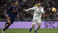 Gelandang Real Madrid, Marco Asensio, berebut bola dengan gelandang Valencia, Daniel Parejo, pada laga La Liga di Stadion Santiago Bernabeu, Madrid, Sabtu (1/12). Madrid menang 2-0 atas Valencia. (AFP/Oscar Del Pozo)
