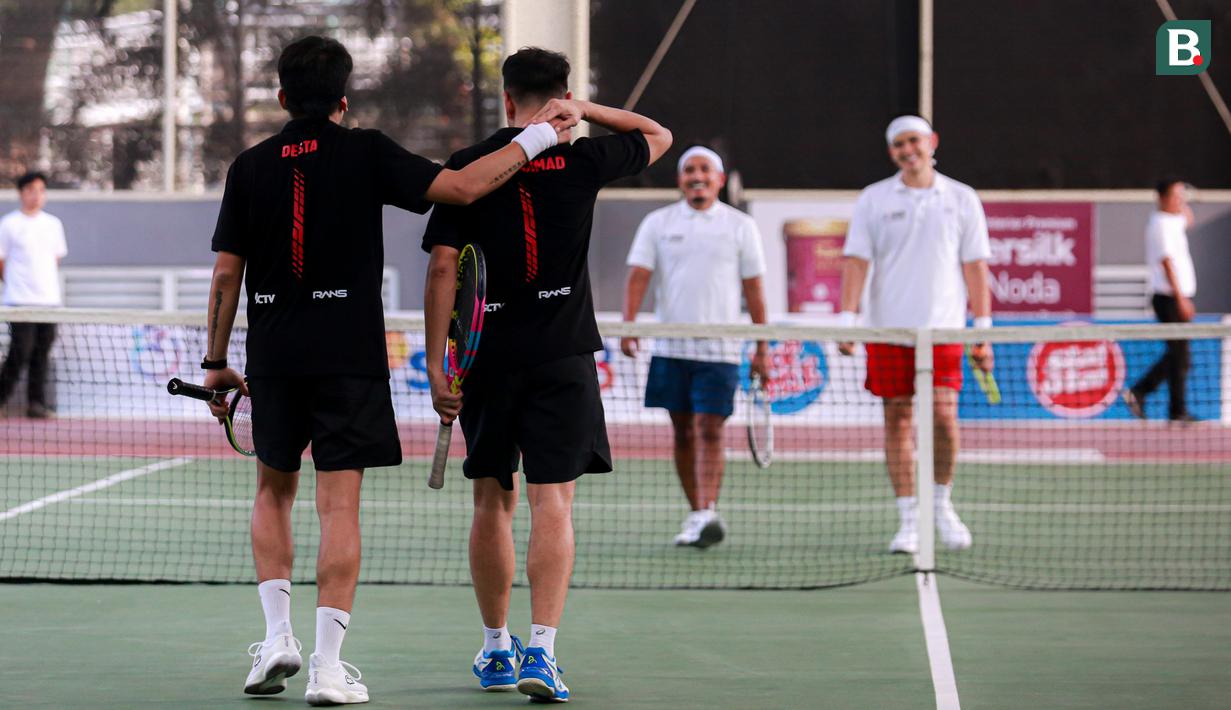 Pasangan selebritas Indonesia, Deddy Mahendra Desta (kiri) dan Raffi Ahmad melakukan selebrasi setelah mengalahkan pasangan Rezky Aditya dan Tanta Ginting pada laga tenis nomor ganda putra Turnamen Olahraga Selebriti Indonesia di GOR UNJ, Jakarta, Minggu (30/07/2023). Raffi dan Desta menang dengan skor 4-6, 6-4, dan 6-4. (Bola.com/Bagaskara Lazuardi)
