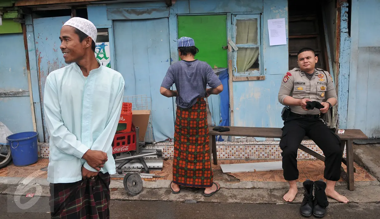 Warga bersama anggota polisi seusai melaksanakan Shalat Jumat di sebuah masjid di kawasan Kalijodo, Jakarta, Jumat (26/2). Shalat Jumat ini merupakan yang terakhir sebelum penertiban kawasan Kalijodo oleh Pemkot DKI. (Liputan6.com/Gempur M Surya)
