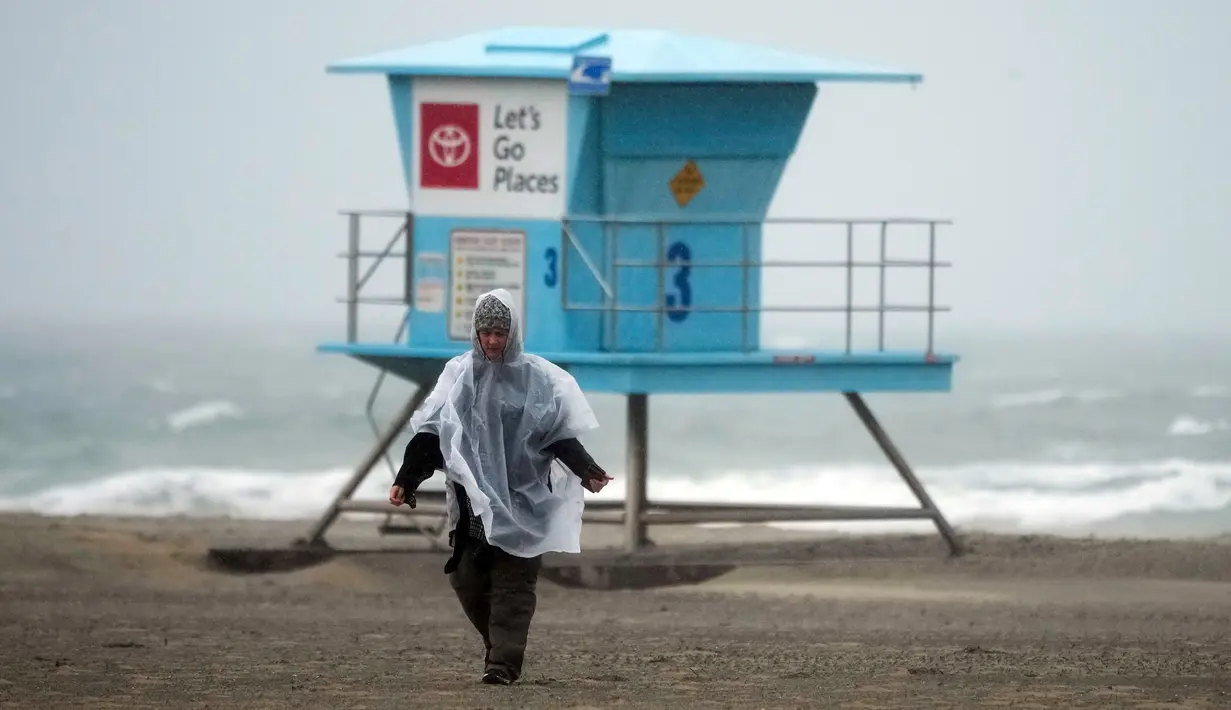 Seorang petugas pantai berjalan di sepanjang pantai di Huntington Beach, California, Amerika Serikat, 24 Februari 2023. California dan bagian lain di Barat menghadapi salju lebat dan hujan dari badai musim dingin terbaru yang melanda Amerika Serikat. (AP Photo/Ashley Landis)
