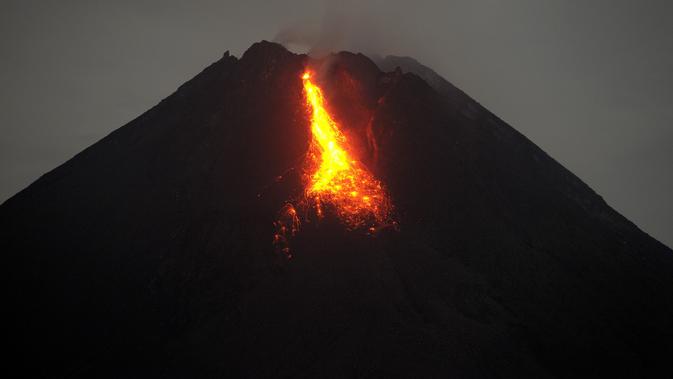 Gunung Merapi mengeluarkan lava pijar yang teramati dari Yogyakarta (7/1/2021).  Jarak luncur maksimumnya 800 meter ke arah kali Krasak. (AFP/Agung Supriyanto)