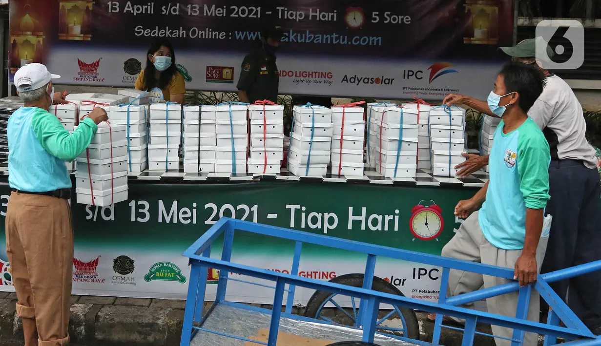 Petugas menata takjil gratis untuk dibagikan kepada warga di Jalan Cempaka Putih Tengah XXI, Jakarta, Rabu (14/4/2021). Pembagian takjil gratis ini dilakukan dengan menerapkan protokol kesehatan ketat. (Liputan6.com/Herman Zakharia)