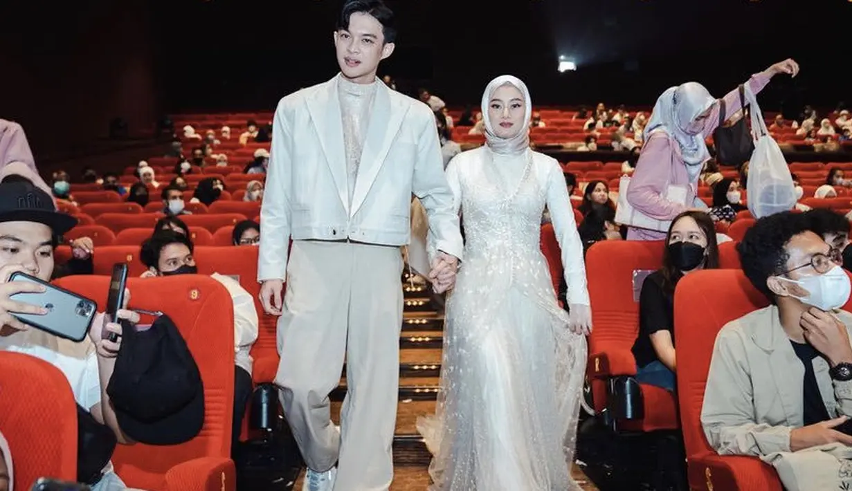 <p>Warna dress Dinda pun serasi dengan sang suami, Rey, mengenakan blazer pendek dengan inner dikombinasikan dengan celana cokelat dan sneakers putih. @dindahw</p>