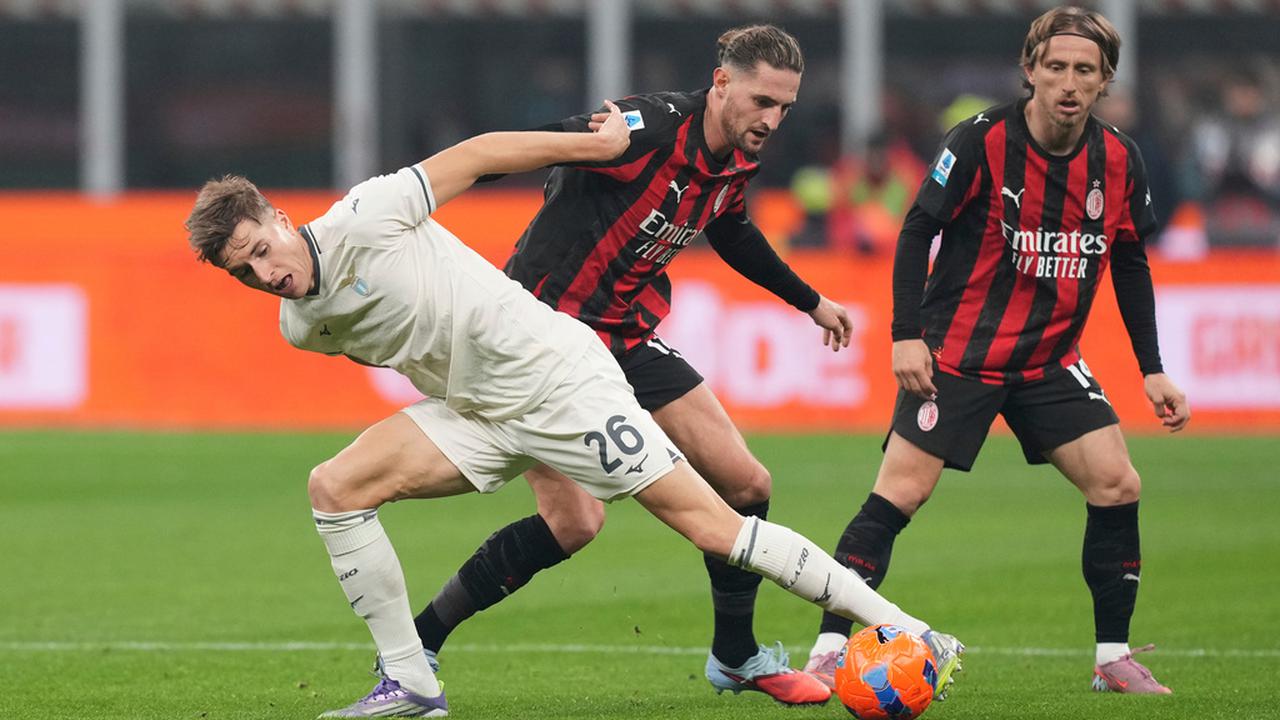 Luka Modric dari AC Milan melihat rekan setimnya, Adrien Rabiot, berebut bola dengan pemain Lazio, Toma Basic